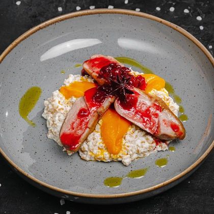 Грудка утки с полбой, кремом из моркови и брусничным соусом